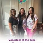 Three smiling women pose at a Volunteer of the Year event.